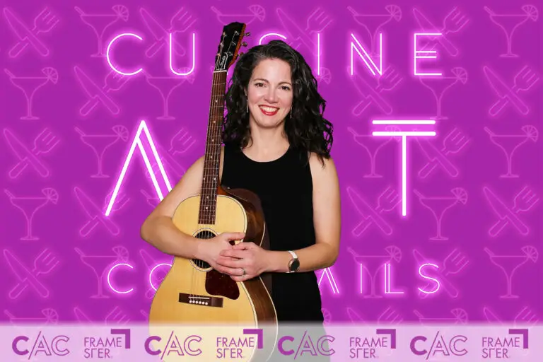Female guitarist posing in front of AI green screen digital background, fully custom design, during Cincinnati CAC private event using Framester Open Air booth.
